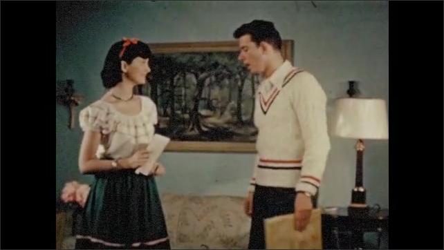 1940s: Teenage boy and girl talking in living room. Boy talking.