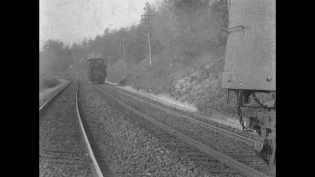 1900s: Engine car of train moves down tracks.  Train stops.  Robbers jump off train and run into woods.  Men cross stream and retrieve horses.