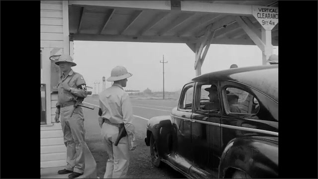1940s: At military checkpoint, man opens briefcase in trunk of car for MPs to see. Man shuts trunk. Man gets in car, drives away from checkpoint. Man walks across field.