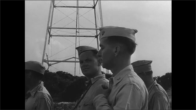 Wake Island 1940s: Marine officers raise the flag. Japanese soldiers salute. American flag. Marine officers. Officers tour the island. Bombed hanger. Airplane wreckage. Damaged roundel. 