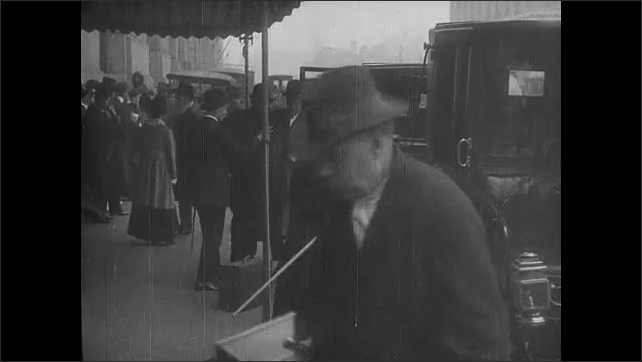 1910s: Title cards. People and vehicles on street.