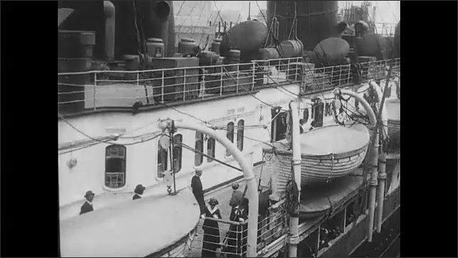 1910s: People on the deck of the Lusitania. Title card. View of lifeboats on deck of ship.