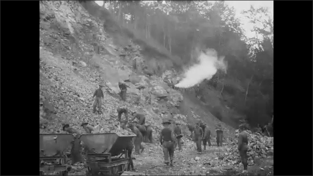 1920s: Laborers at work. Blast from hillside. Laborers work on hillside. Laborers stack stones.