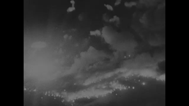 1910s: Explosions and fires on ground at night from bombs. Flying over explosions on ground.