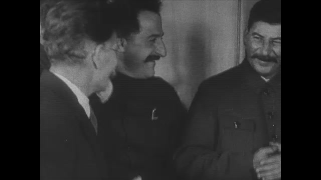 1920s: Stalin talks with people. Photograph of Grigory Zinoviev. People stand by train cars. Farmers harvest grain. Woman slices bread loaf.