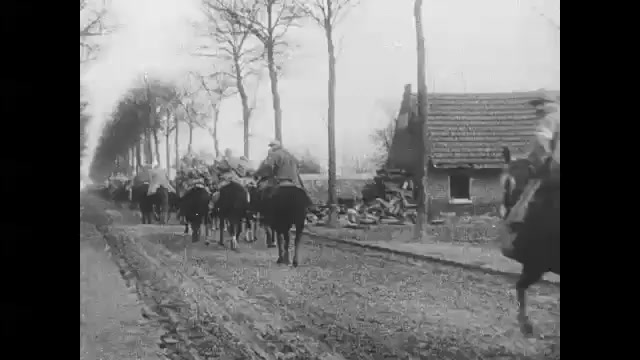 1910s: Soldiers ride horses through village.  Men on hill.  Tank and cannon fire.  Church.  Field.  Explosion.  Cars drive down street.  Soldiers walk through trench.