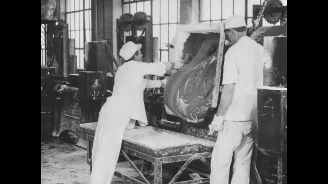 1910s: Two workers in factory pull large blob of gum from machine. Intertitles. People working in large hotel kitchen. Intertitles.