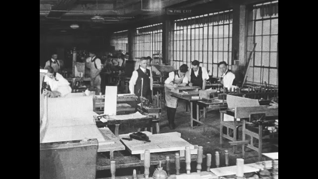 1910s: People working in factory. Intertitle cards. People working on assembly line. Intertitles. Machine operates in factory. End titles.