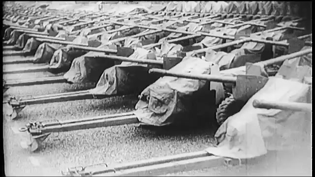 1940s: Bombs.  Airplanes.  Man checks propeller.  Men unload ship.  Men push boxes down conveyor belt.  Man drives forklift.  Warehouse.  Trains.