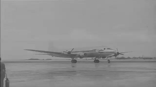1940s: Air Transport Command plane lands on runway. Two men in suits ...