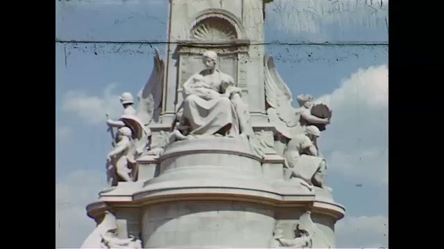 1940s: angelic statues on fountain, car driving in busy traffic in London