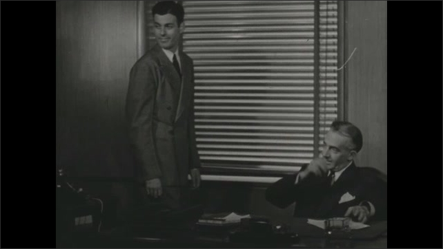 1940s: Low angle, man and boy looking, pointing. Men at desk, boy enters, Man talks to boy. Boy talking. 
