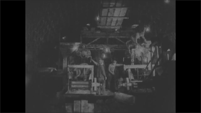 1930s: Animation of tunnel shield digging. Shots of men working in tunnel. Man looking through surveying equipment. Animation, tunnel segments progressing under river. 
