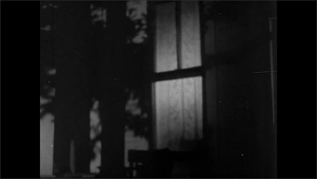 1940s: Man and woman at table in cafÃ© drink and talk. Nighttime, light comes on inside house, on porch. Man and woman walk on to porch from inside house and talk.