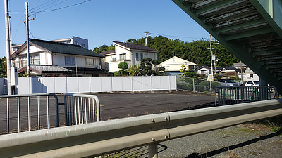 A parking lot and distant houses.