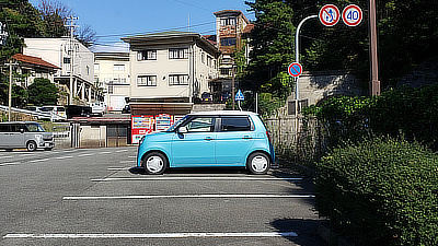 Teal car in a parking lot.