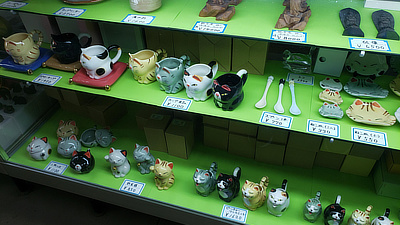 Cat figurines in a display case.