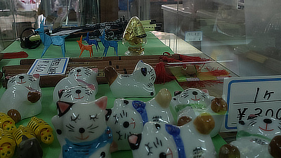 Ceramic cat figurines in a display case.