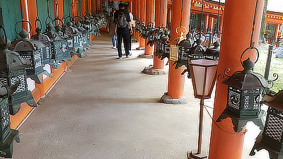 People walk along a path inside the outer wall of the shrine.