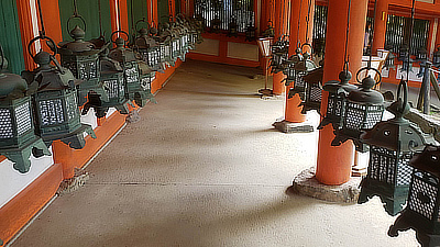 Metal lanterns line a path through part of a shrine.