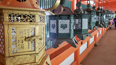 Metal lanterns line a walkway in a shrine.