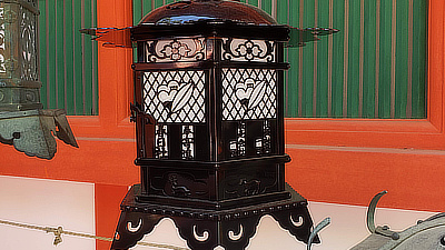 A metal lantern hanging along one of the walkways of the shrine.