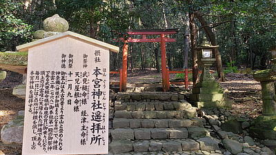 Stone steps leading up to a gate and forest area.