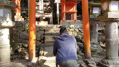 A man takes a picture of one of the small shrines.