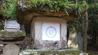 A shrine with grass growing out of the top.