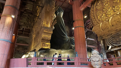 Rear view of the Great Buddha statue, notice the people walking near the base.