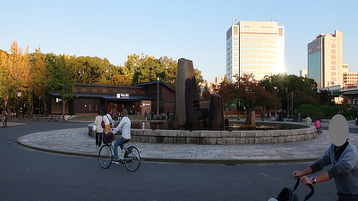 Visitors ride bikes near a fountain in the Castle park.