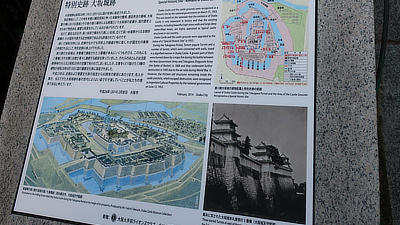 A sign with historical maps of Osaka Castle.