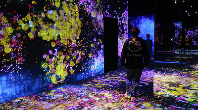 John walks down a hallway in the "Forest of Flowers and People" exhibit.