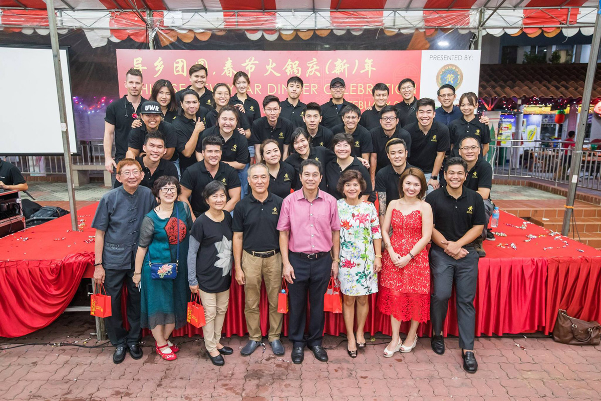 Huang clan members gather for a group photo at an outdoors event.