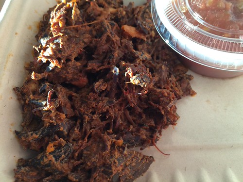 A close up of brisket in a to-go container.