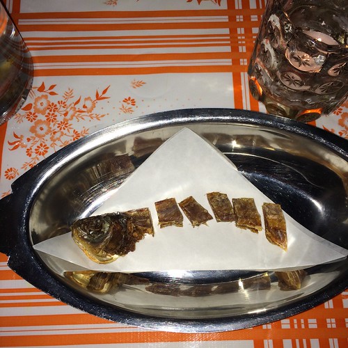 A preserved and segmented herring in a silvery bowl.