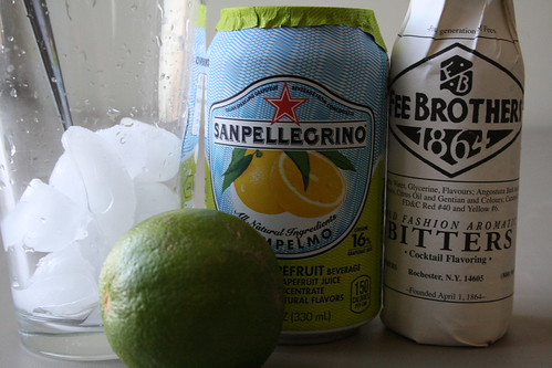 A glass with some ice, a lime, a grapfruit soda, and bitters. Magic in the making.