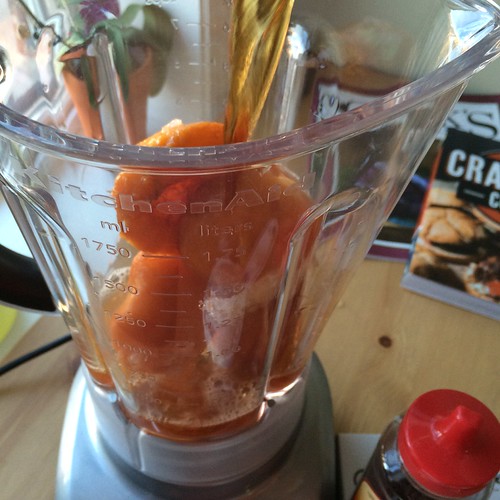 Peaches in a blender. Tea being poured over them.