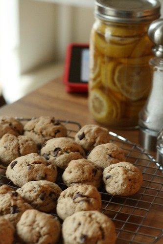Meatball cookies on a cooling rack in the foreground. A mason jar full of lemon slices midway, and an out-of-focus iPad in the backgroud.