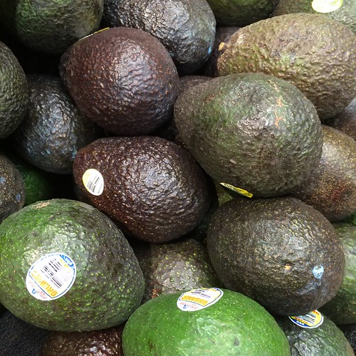 A pile of avocados of varying ripeness.