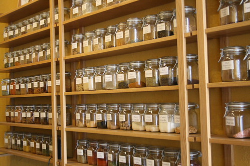 Wall mounted shelves filled with bulk spices.